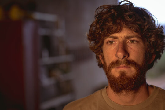 Thoughtful bearded caucasian blacksmith looking away in metal manufacturing industry