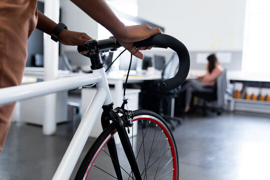 Cropped image of businesswoman with bicycle in creative office