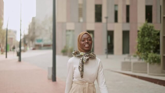 Stylish Muslim female walking on pavement