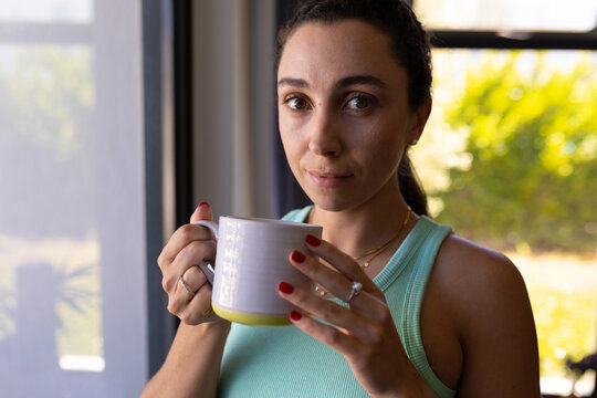 Portrait of caucasian woman holding a coffee cup at home