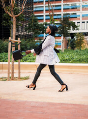 Obraz premium Stylish black woman enjoying pleasant walk in city park