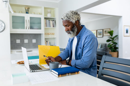 Bearded senior african american businessman using laptop at home office