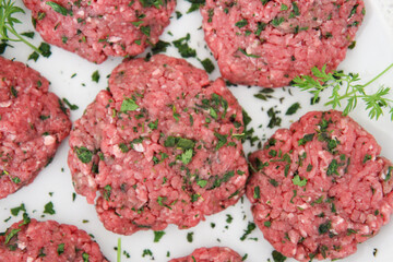 Raw Herbed Meat Patties Close Up Top View Against White Background