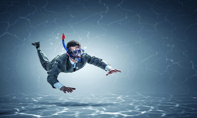 Young businessman in suit swimming - Powered by Adobe