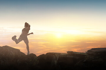 Woman running against sunset sky