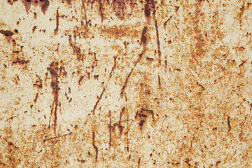 Brown beige abstract textured background with red hues. A weathered, rust-eaten textured sheet of metal with traces of paint residue.