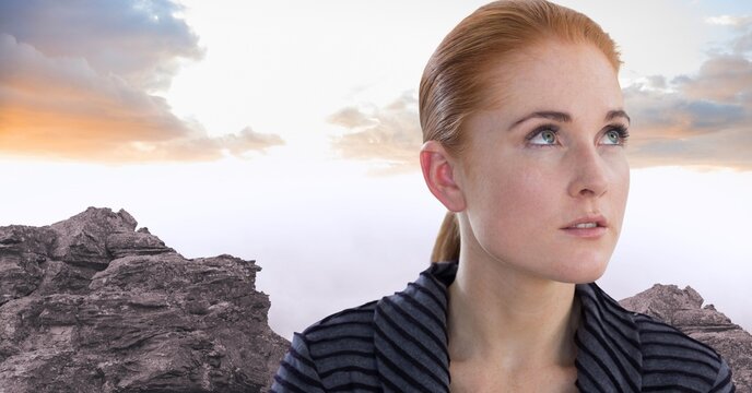 Composite image of caucasian woman looking away against sunset sky over rocks