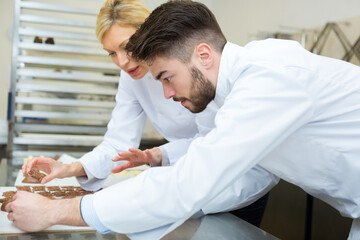 Obraz premium two pastry chefs preparing croissants in a confectionery laboratory