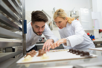 Obraz premium professional chefs looking at little novelyty chocolate hats