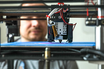 Naklejka premium An engineer is setting up a machine for 3D printing, a printer for volumetric printing of parts.