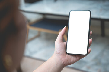 Close up women using a smartphone with an empty white screen at home.