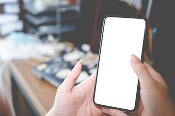 Close up business women using a smartphone with an empty white screen at the office workplace.