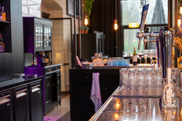 Interior of classic bar with beer taps and empty glasses in cafe