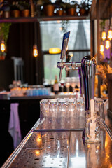 Interior of classic bar with beer taps and empty glasses in cafe