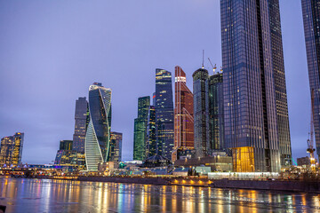 Plakat April 1, 2022, Moscow Russia. Moscow City International Business Centre skyscraper buildings with panoramic windows night view. Moscow City at night. Lights are reflected in the river.