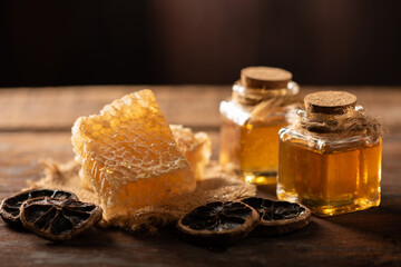 Homemade honey jar with honeycomb on a rustic wooden table