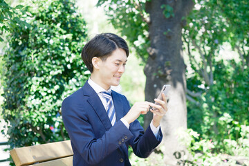Obraz premium ビジネスマン スマホ 屋外