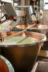 Process of making wheels of parmigiano-reggiano parmesan cheese on small cheese farm in Parma, Italy
