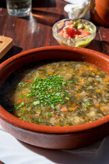 Dinner at guachinche, typical Canary Island establishment on Tenerife, where locally produced white or red wine served accompanied by homemade traditional food, vegetable soup with gofio