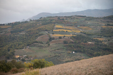 Obraz premium View on hills of Rocco Tuscany, Italy. Tuscan landscape with cypress trees, vineyards, forests and ploughed fields in autumn.