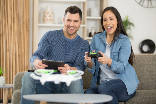 couple flying a drone indoors at home