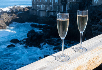 New year celebration with two glasses of champagne or Spanish cava sparkling wine and view on black lava rocks, Canary islands, winter tourists destination
