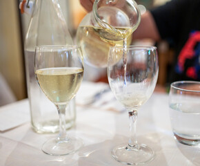 Italian white house wine served in pitcher with two glasses for dinner