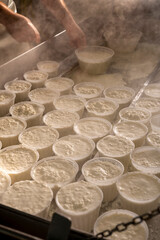 Process of making fresh white soft ricotta whey cheese on small cheese farm in Parma, Italy