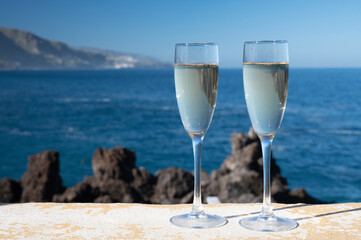 New year celebration with two glasses of champagne or Spanish cava sparkling wine and view on blue Atlantic ocean, Canary islands, winter tourists destination