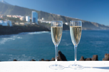 New year celebration with two glasses of champagne or Spanish cava sparkling wine and view on blue Atlantic ocean, Canary islands, winter tourists destination