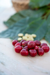 Red ripe arabica coffee berries, green coffee beands and leaves