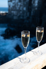 New year celebration with two glasses of champagne or Spanish cava sparkling wine and view on black lava rocks, Canary islands, winter tourists destination