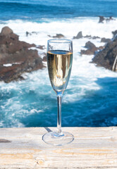 New year celebration with glass of champagne or Spanish cava sparkling wine and view on black lava coast and blue Atlantic ocean, Canary islands, winter tourists destination