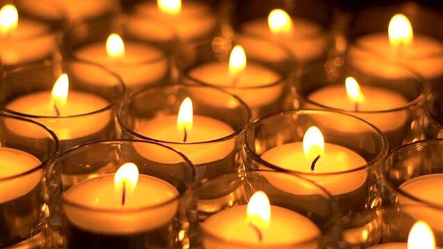 In memoriam.  Remembrance candles flickering - Lit for the departed. Shallow DOF