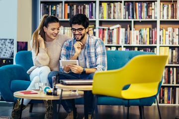 Fototapeta premium Young couple using mobile phone in a cafe.