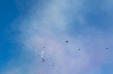 Smoke with ashes from a fire against a sky.