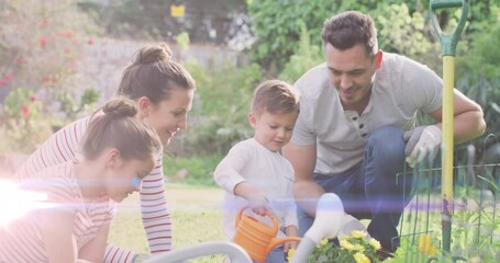 Animation of light spots over happy caucasian family working in garden