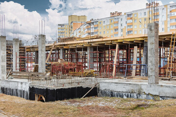 Fototapeta premium Reinforced concrete foundation of a modern monolithic residential building. Prepared formwork with reinforcing mesh for pouring concrete. Monolithic construction technologies.