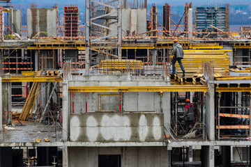 Monolithic frame construction of the building. Workers working at the construction site at home....