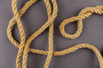 The yellow ship rope against the gray background. The twisted rope is random. Top view. Abstract background