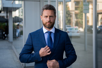 Portrait of businessman in front of modern office.