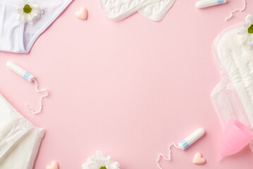 Top view photo of camomile flower buds small hearts lingerie menstrual cup sanitary napkins and tampons on isolated pastel pink background with copyspace in the middle