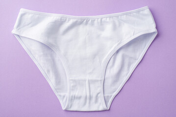 Top view photo of white cotton classic panties on isolated pastel violet background - obrazy, fototapety, plakaty