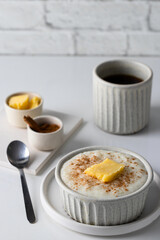 Popular Norwegian rice porridge or risgrot traditionally served with butter and cinnamom on the kitchen table