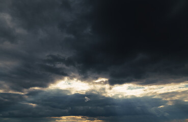beautiful dramatic sky and sunlight, dark silhouette of clouds as background