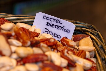 Wicker tray with dried fruits in the market of Seville (Spain), the sign translated into English...
