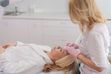 Obraz na płótnie Canvas Facial peeling mask, beauty spa, skin care. Woman getting facial treatment by beautician at SPA salon, closeup