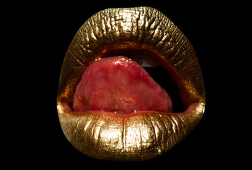 Golden lips with creative art gold metallic lipstick. Gold paint on lips of sexy girl. Sensual woman mouth, isolated background. Isolated woman golden mouth with tongue out.