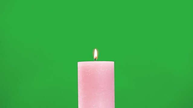 pink candle burns on a green screen
