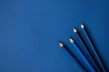 Blaue Buntstifte auf blauem Hintergrund. Freiraum für Text